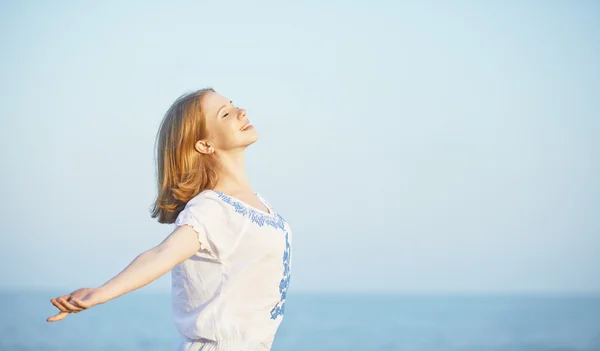 Szczęśliwa młoda kobieta otwarte ramiona do nieba i morza — Zdjęcie stockowe