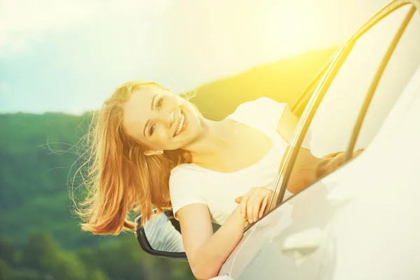 Gelukkige vrouw kijkt uit het raam van de auto op de natuur — Stockfoto