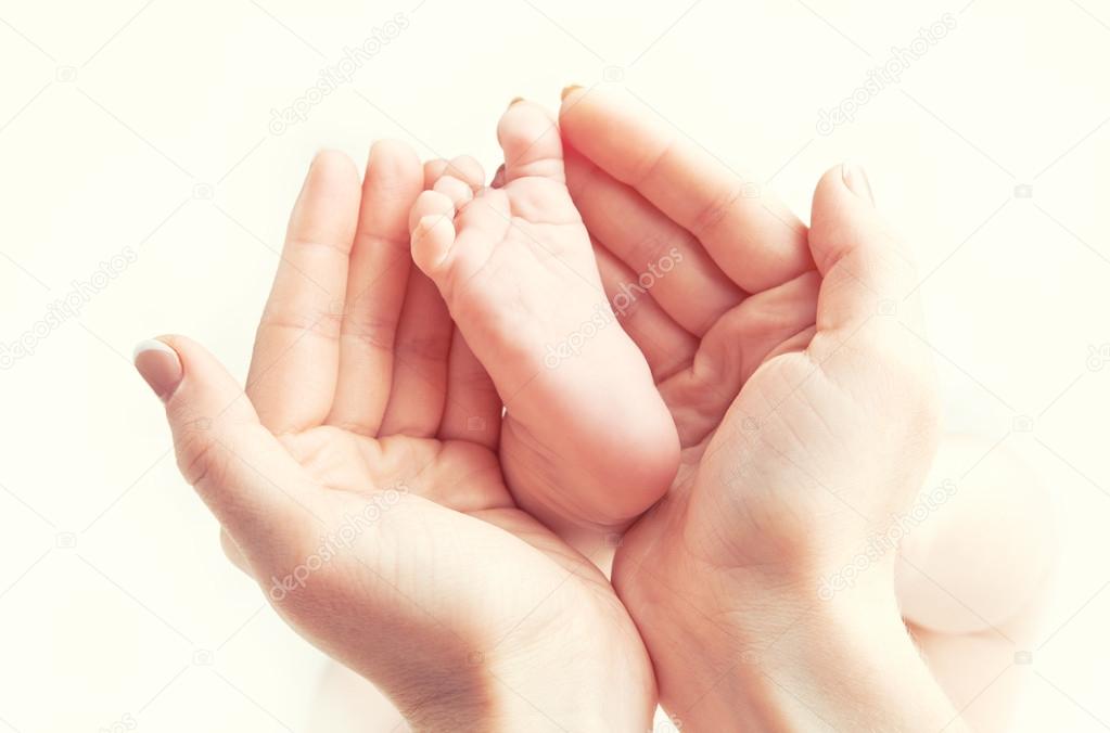 concept of love, parenthood, motherhood. newborn baby foot in mo