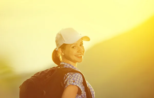 Donna felice turista con uno zaino al tramonto — Foto Stock
