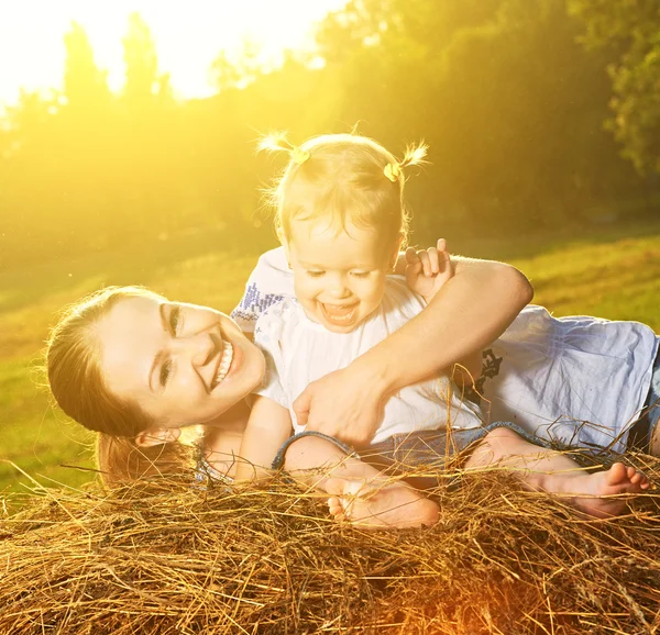 Família feliz na natureza de verão. Mãe e bebê filha no feno — Fotografia de Stock