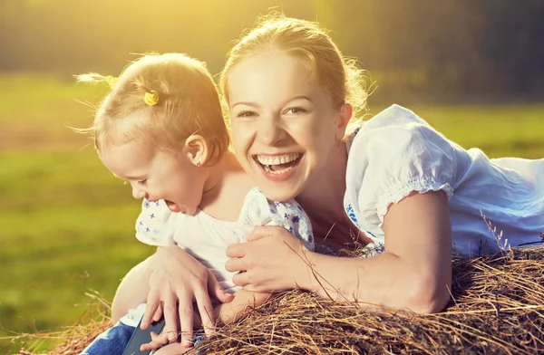 Glückliche Familie in sommerlicher Natur. Mutter und kleine Tochter im Heu, Stroh — Stockfoto