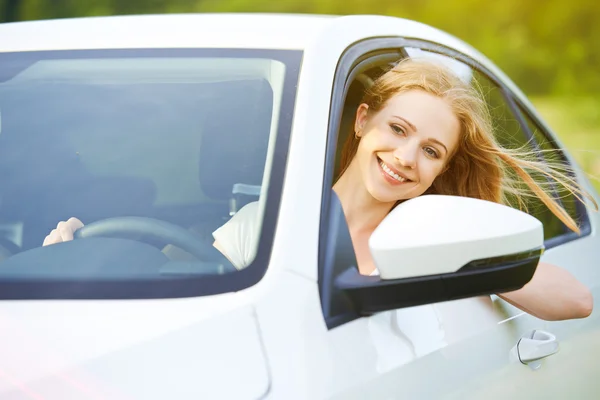 Happy woman looks out the car window on nature — Stock Photo, Image