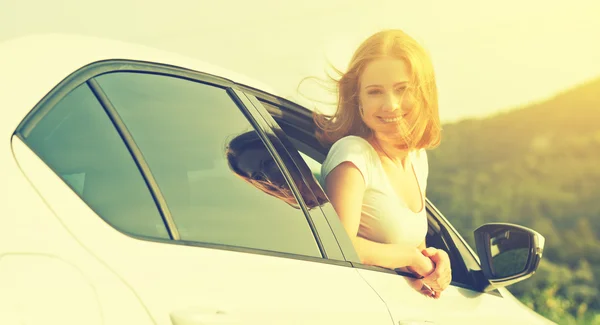 Happy woman looks out the car window on nature — Stock Photo, Image