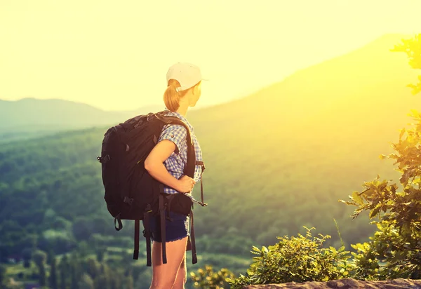 Mujer feliz turista con una mochila en la naturaleza —  Fotos de Stock