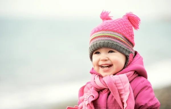 Menina feliz bebê em chapéu rosa e cachecol ri — Fotografia de Stock