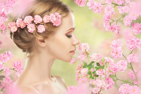 年轻美丽的女子和她的头发在粉红色的花朵 — 图库照片