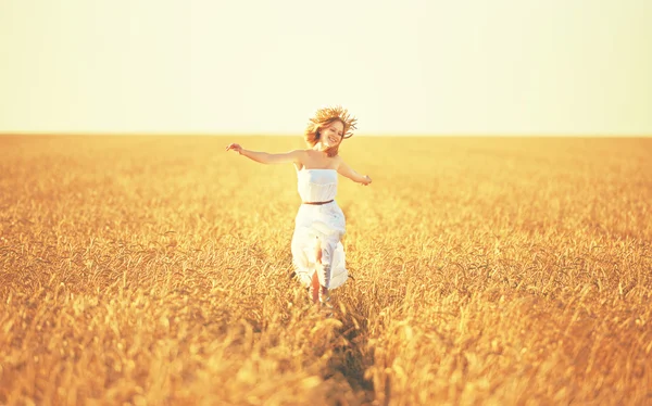 Счастливая молодая женщина наслаждается жизнью на золотом пшеничном поле — стоковое фото