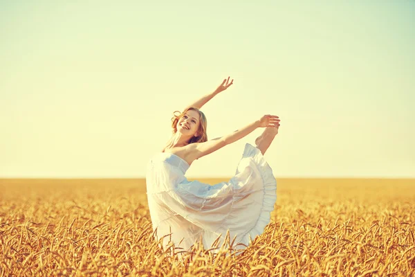 Happy young woman enjoying life in golden wheat field — Stock Photo, Image