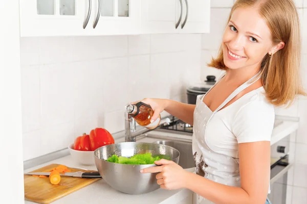 Mulher feliz dona de casa preparando salada na cozinha — Fotografia de Stock