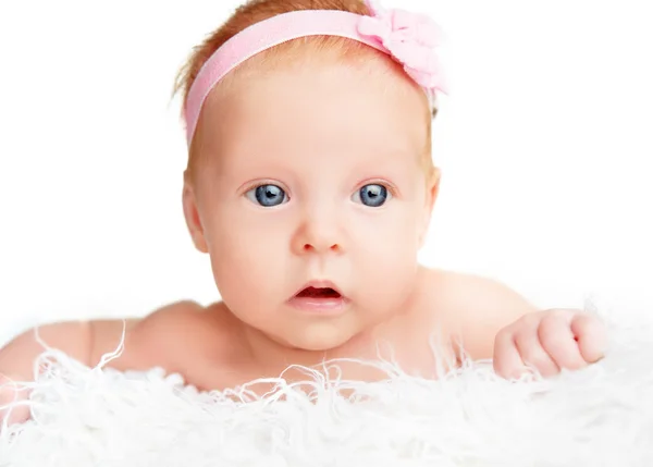 Cute  newborn baby girl with a pink flower ribbon — Stock Photo, Image