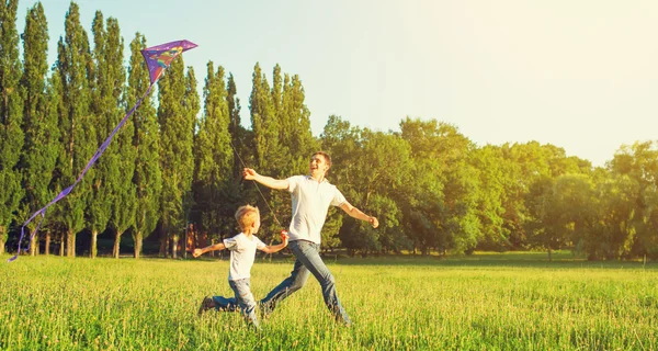 Papà e figlio bambino che volano con un aquilone nella natura estiva — Foto Stock