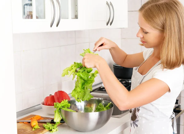 Mulher feliz dona de casa preparando salada na cozinha — Fotografia de Stock