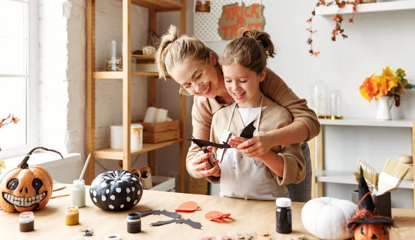 Happy smiling family mother and daughter making Halloween home decorations together — Stock Photo, Image