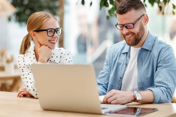 Two positive cheerful colleagues man and woman working together on project at outdoor cafe — Stock Photo, Image