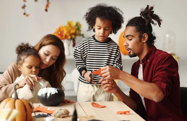 Giovane gioiosa famiglia afroamericana madre, padre e due bambini che si preparano per Halloween a casa — Foto Stock