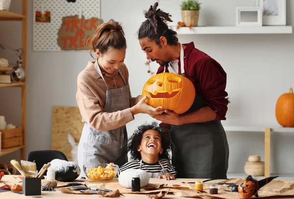 Feliz familia madre padre y pequeño hijo sonriendo mientras que hacer jack o linterna — Foto de Stock