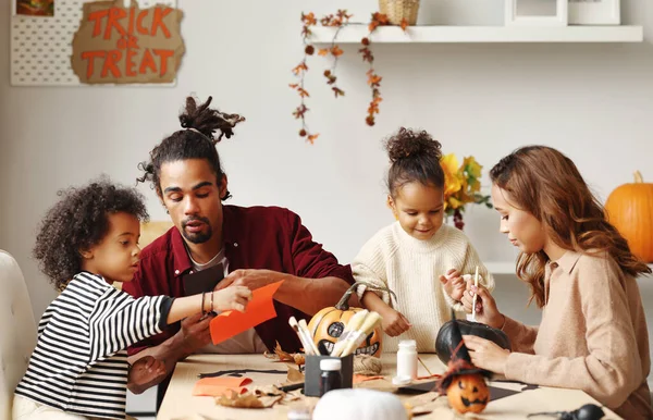 Νεαρή χαρούμενη αφροαμερικάνικη οικογένεια μητέρα, πατέρας και δύο παιδιά που ετοιμάζονται για το Halloween στο σπίτι — Φωτογραφία Αρχείου