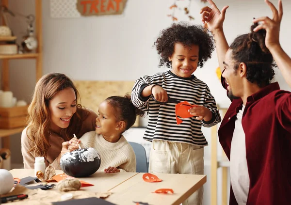 Ung glad afrikansk amerikansk familj mor, far och två barn förbereder sig för Halloween hemma — Stockfoto