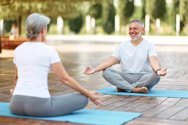 Boldog idős család pár meditálnak együtt a szabadban a reggeli jóga edzés alatt — Stock Fotó