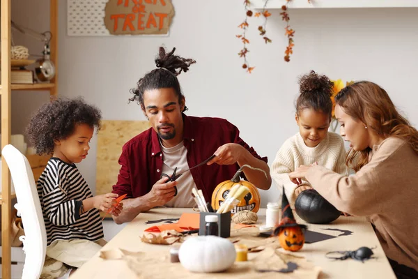 Young joyful african american family mother, father and two kids preparing for Halloween at home — Stock Photo, Image