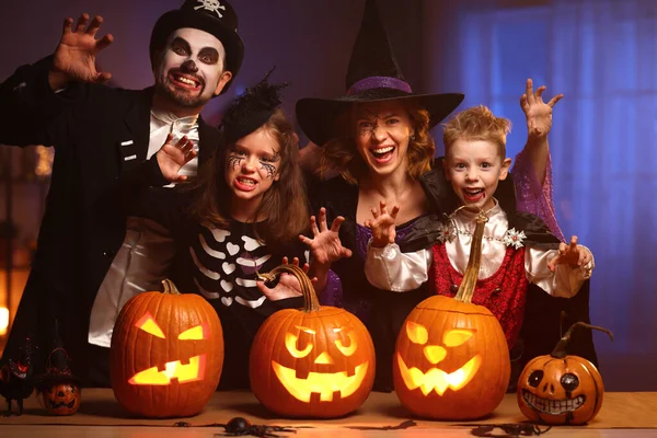 Jovem família mãe pai e crianças em trajes de Halloween celebrando todas as vésperas hallows em casa — Fotografia de Stock