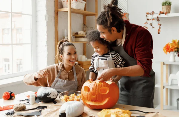 Alegre afroamericano familia madre, padre y niño hijo disfrutando de la preparación de Halloween en casa Imagen De Stock