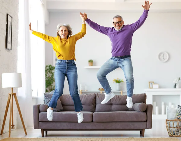 Longitud completa de feliz activo enérgico senior caucásico familia pareja saltar y divertirse juntos Imagen De Stock