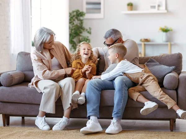 Speelse kinderen en grootmoeder met opa kietelen elkaar terwijl tijd doorbrengen samen in het weekend — Stockfoto