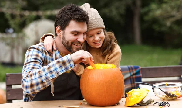 Father and daughter carving pumpkin for halloween in backyard — Stock Photo, Image