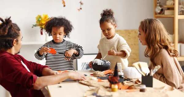 Jeune joyeuse famille afro-américaine mère, père et deux enfants se préparent pour Halloween à la maison — Photo