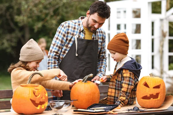 Padre e figli intaglio zucca per Halloween in cortile — Foto Stock