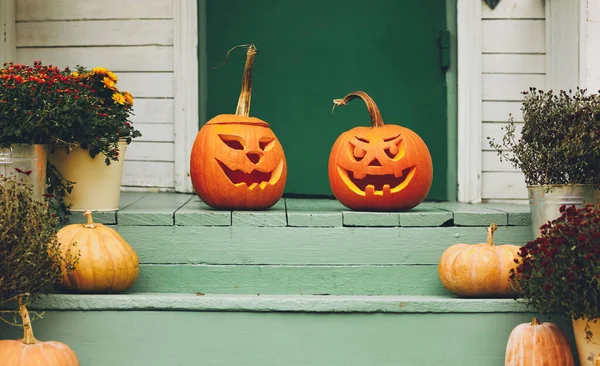 Hus med halloween orange pumpa dekoration, jack o lyktor med kusliga ansikten på verandan — Stockfoto