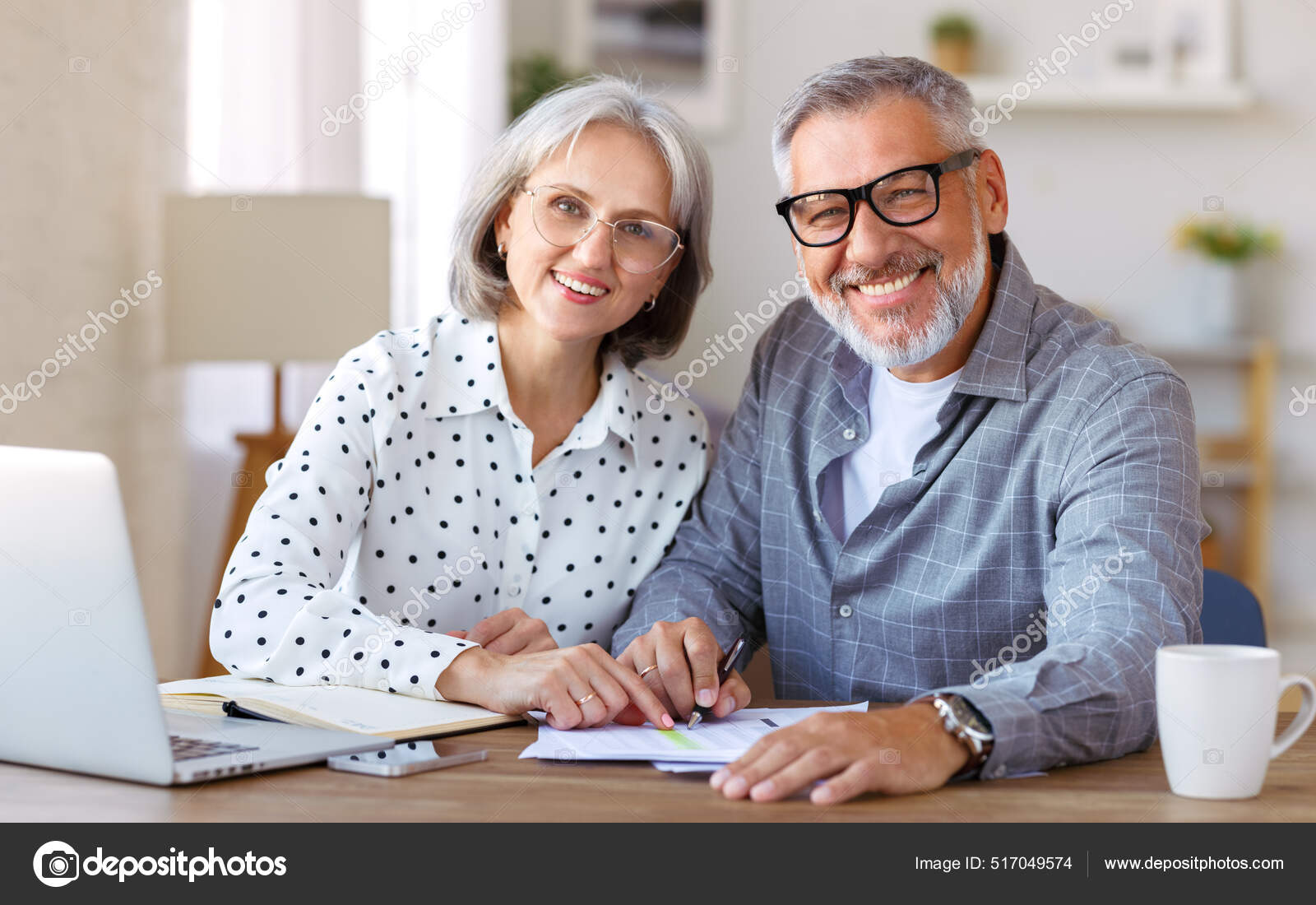 Pareja de la familia mayor que estudia en linea juntos en casa mirando el ordenador portatil mientras esta sentado en la mesa Foto de stock 517049574 evgenyataman