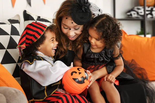 Familia africana feliz en trajes celebrando vacaciones de Halloween juntos en casa —  Fotos de Stock
