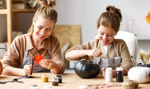 Feliz sorrindo família mãe e filha fazendo decorações para casa de Halloween juntos — Fotografia de Stock