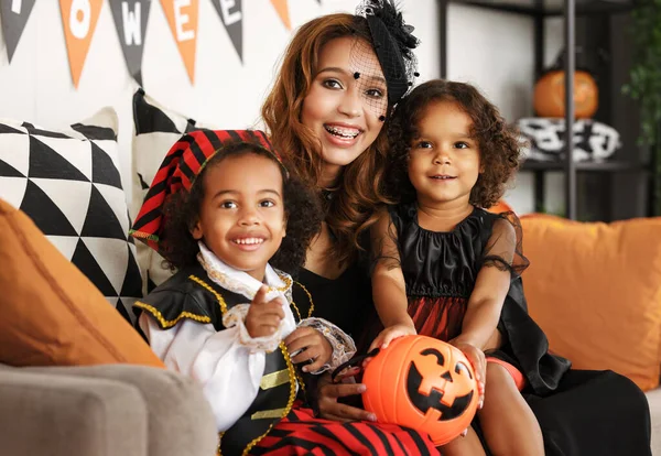 Familia africana feliz en trajes celebrando vacaciones de Halloween juntos en casa —  Fotos de Stock