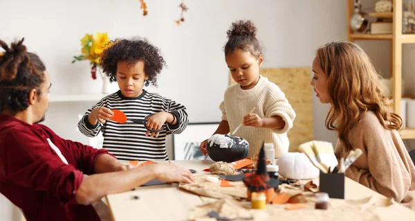 Junge fröhliche afrikanisch-amerikanische Familienmutter, Vater und zwei Kinder bereiten sich zu Hause auf Halloween vor — Stockfoto