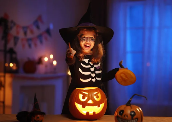 Portrait de mignonne petite fille excitée en costume de sorcière avec baguette magique faisant sort — Photo