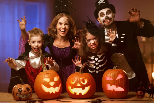 Jovem família mãe pai e crianças em trajes de Halloween celebrando todas as vésperas hallows em casa — Fotografia de Stock