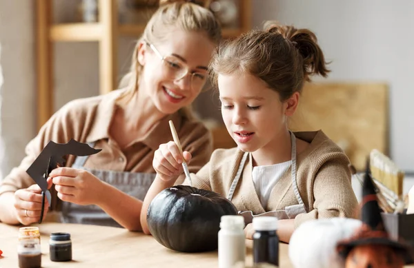 Šťastné usmívající se rodina matka a dcera dělat Halloween domácí dekorace společně — Stock fotografie