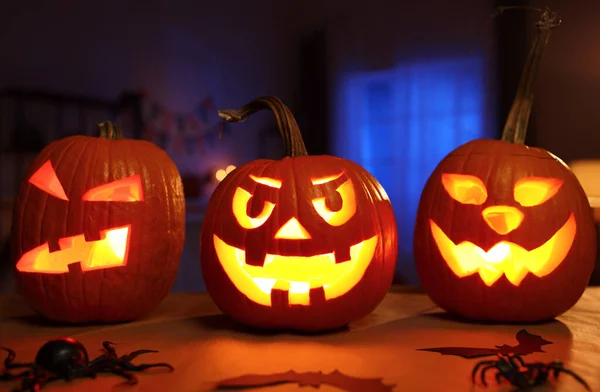 Kísérteties halloween otthoni dekoráció sötét szobában faragott sütőtökkel és pókokkal díszített — Stock Fotó