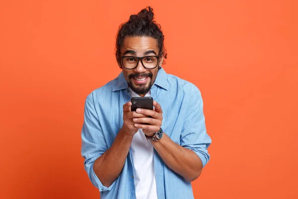Щасливий молодий афроамериканець, який читає чудові новини по смартфону. — стокове фото