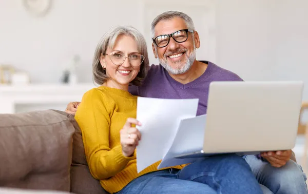 Ευτυχισμένο ζευγάρι ηλικιωμένων διαβάζει καλά νέα στην επιστολή, ενώ πληρώνουν λογαριασμούς σε απευθείας σύνδεση στο laptop — Φωτογραφία Αρχείου