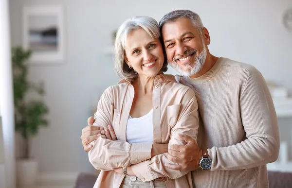 Hermosa sonriente pareja de ancianos marido y mujer mirando a la cámara con amor — Foto de Stock