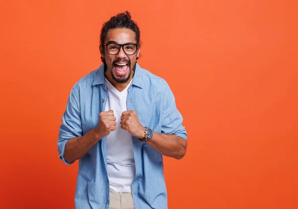 Opgewonden jonge Afro-Amerikaanse man wint armen heffen met gebalde vuisten en het vieren van succes — Stockfoto