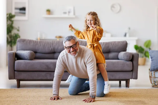 Schattig klein meisje kleindochter spelen en plezier hebben met actieve positieve opa thuis — Stockfoto