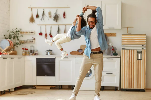 Dad spinning his son in the air while playing together and having fun at home — Stock Photo, Image