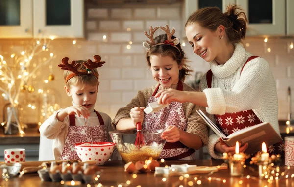 Jonge lachende vrouw moeder maken deeg voor kerst peperkoek koekjes met schattige kleine kinderen — Stockfoto