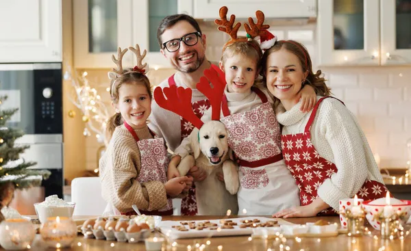 Ευτυχισμένοι οικογενειακοί γονείς με δύο παιδιά και golden retriever κουτάβι, ενώ κάνει χριστουγεννιάτικα μπισκότα στο σπίτι — Φωτογραφία Αρχείου